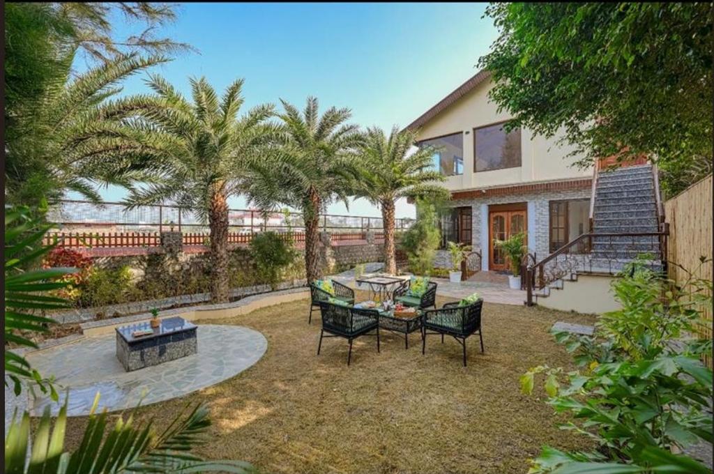 a house with a patio with a table and chairs at Manovan Resort by Eastlynn Experiences, Jim Corbett in Belparāo