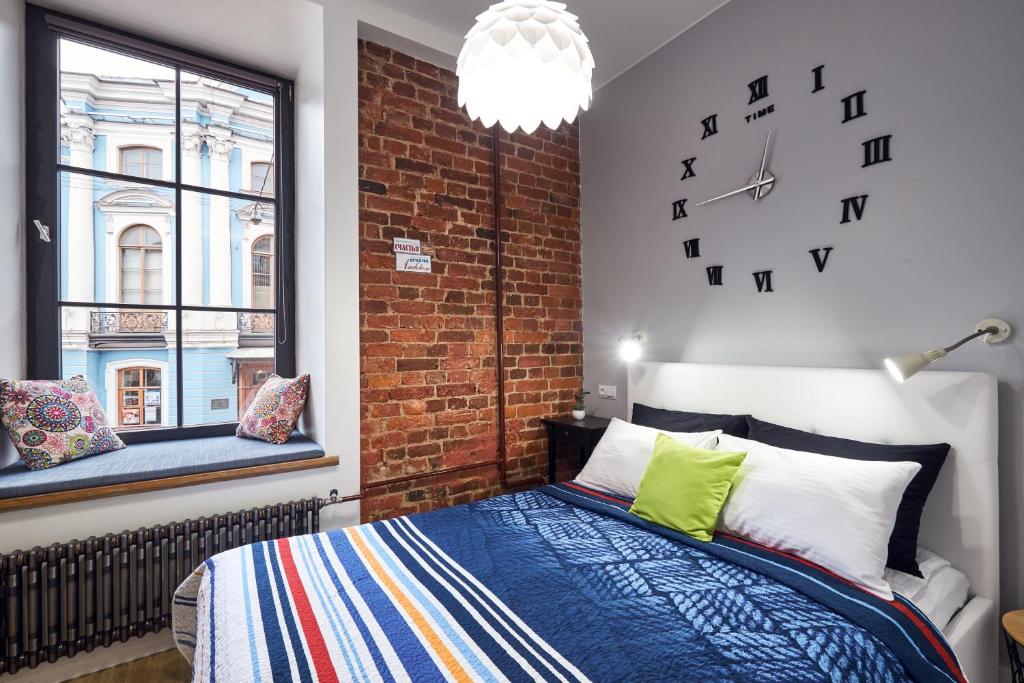 a bedroom with a bed and a brick wall at Kaleidoscope on Italyanskaya in Saint Petersburg