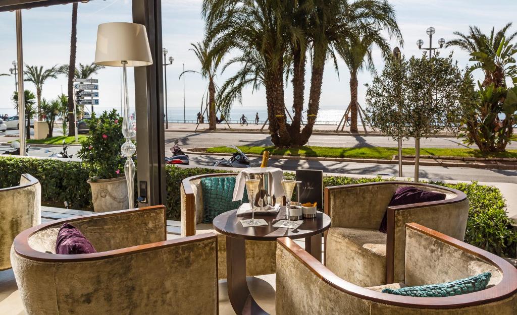 a restaurant with a table and chairs with a view of the ocean at Westminster Hotel & Spa Nice in Nice