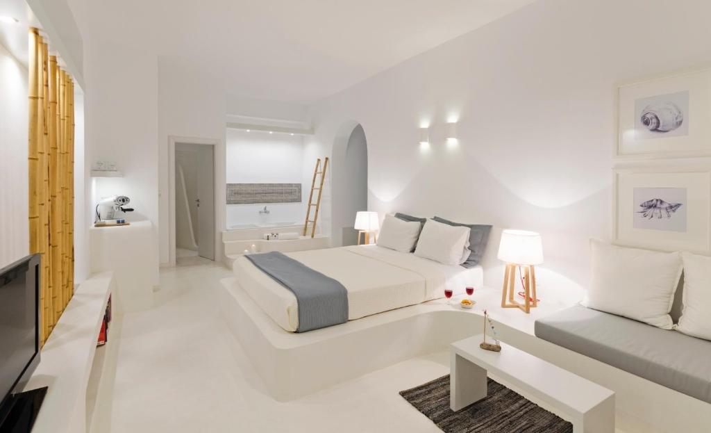 a white bedroom with a bed and a couch at Astypalaia Hotel Palace in Astypalaia