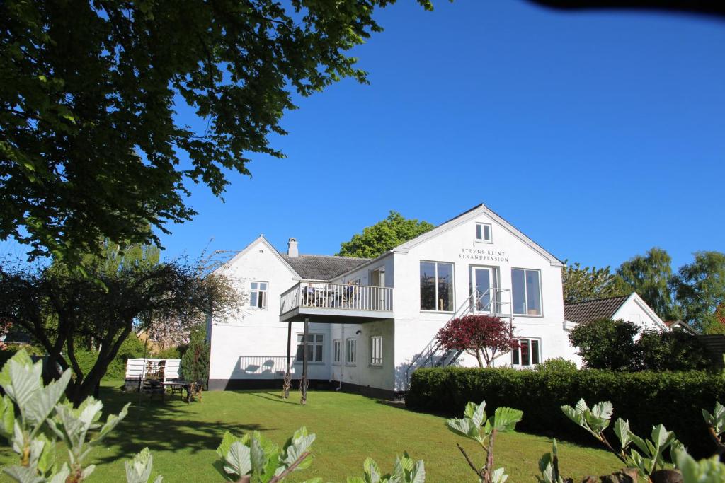 uma grande casa branca com um grande quintal em Stevns Klint Strandpension em Rødvig