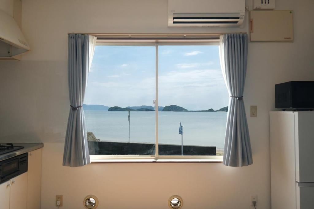 a window in a kitchen with a view of the ocean at 空海の宿平生 in Saga
