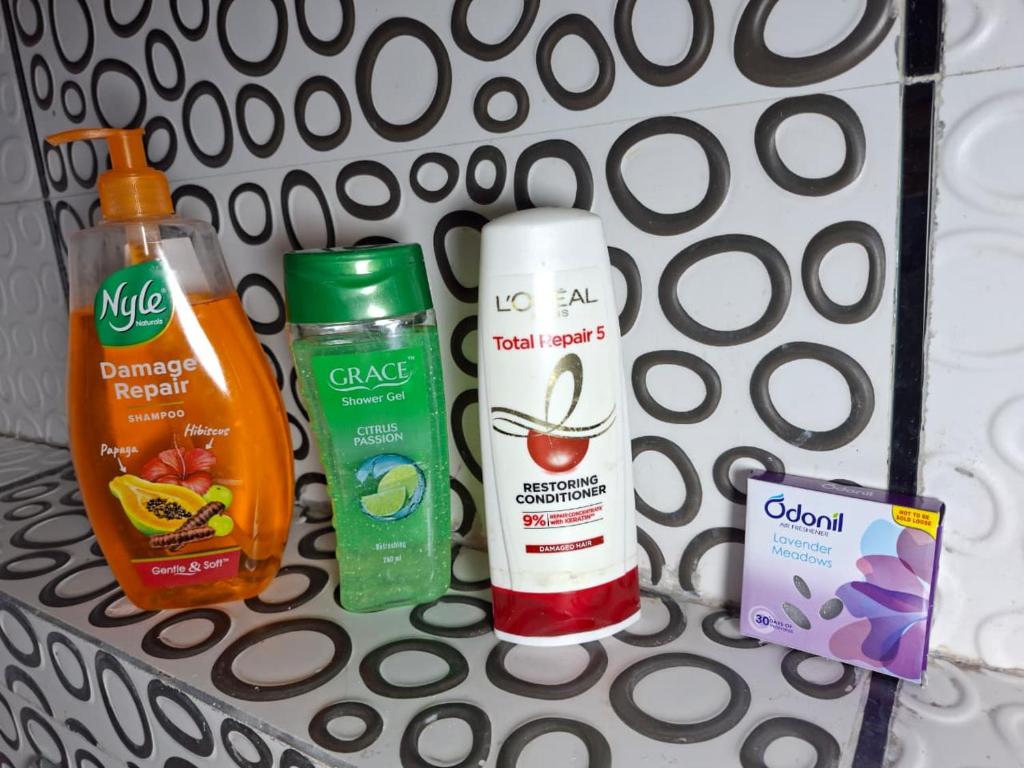 a shelf with bottles of sunscreen and other products on it at Angel's Cottage in Jaipur