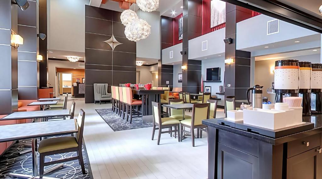 a restaurant with tables and chairs and a bar at Hampton Inn and Suites Marksville in Mansura
