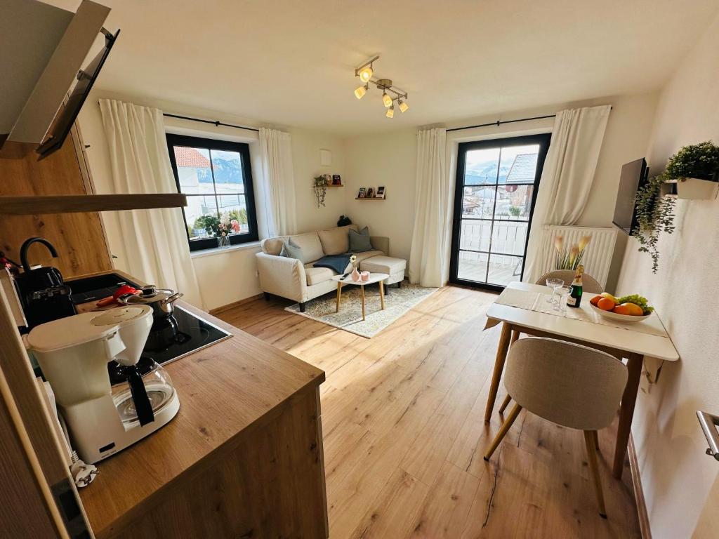 a small kitchen and living room with a table and chairs at Ferienwohnung Alpen Auszeit in Rieden