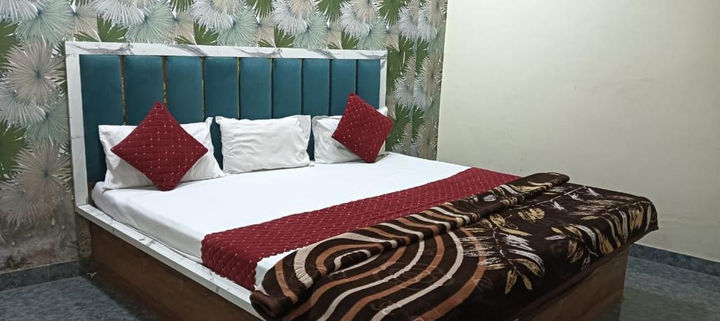 a bed with red and white pillows on it at Sheetal palce hotel in Ujjain