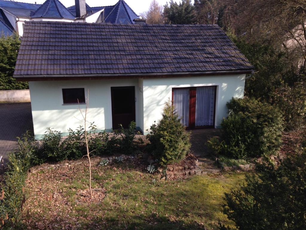 una pequeña casa blanca al lado de una colina en Ferienhaus Gappa, en Bad Wilsnack