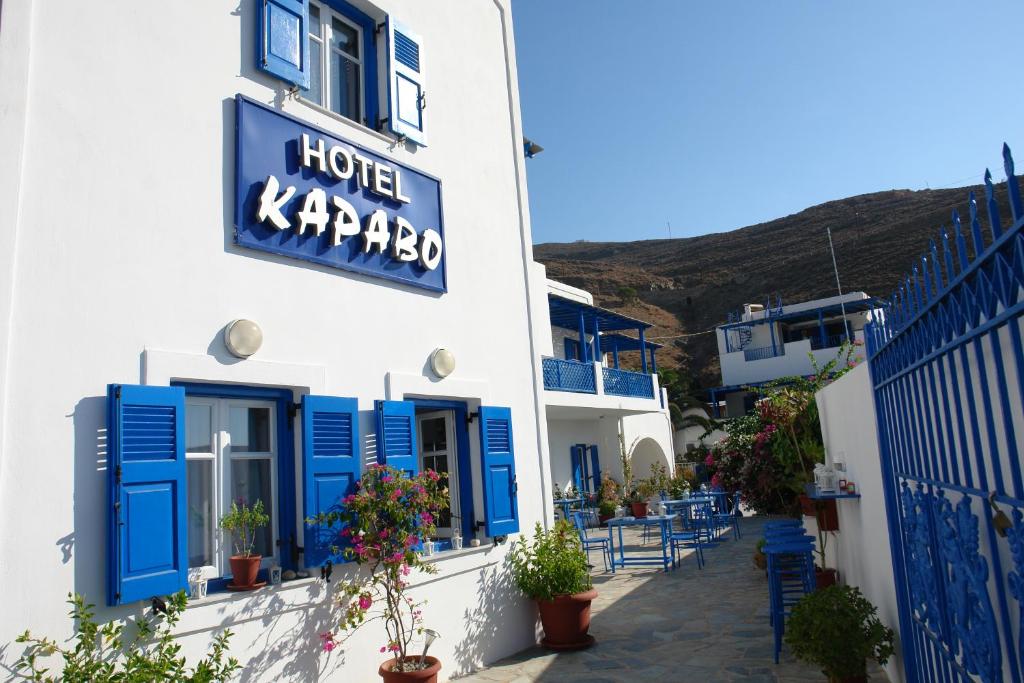 a building with blue shutters and a hotel kazpes sign at Karabo Hotel in Livadi Astypalaias