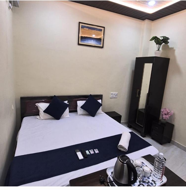 a bedroom with a bed with blue and white pillows at Sri Ram Shankar-Saryu Ghat in Ayodhya