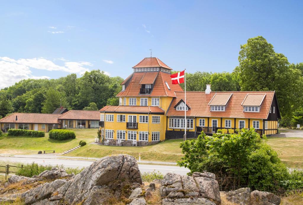 ein großes gelbes Gebäude mit einer kanadischen Flagge darauf in der Unterkunft Stammershalle Badehotel in Bådsted