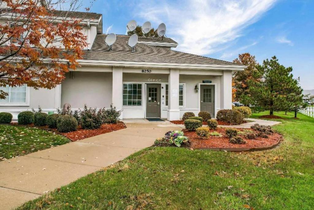 a white house with a driveway and a yard at Quality Inn Fishers - Indianapolis in Fishers
