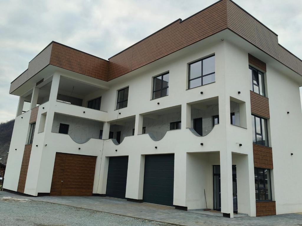 a white building with a brown roof at Gosen Grand Residence in Sângeorz-Băi