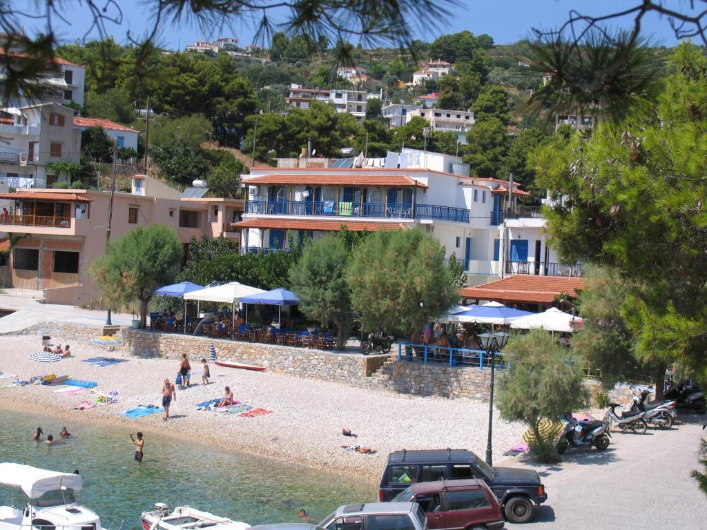 un groupe de personnes sur une plage dans l'eau dans l'établissement Nostos, à Patitiri