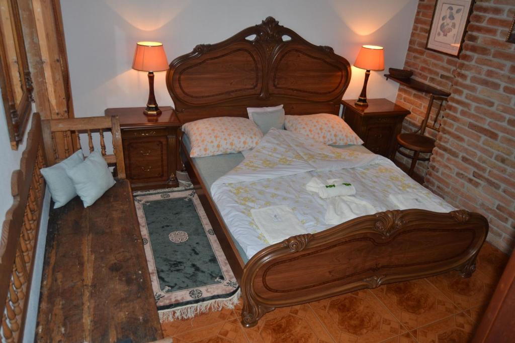 een slaapkamer met een houten bed met 2 tafels en 2 lampen bij Excellent Location in Bratislava