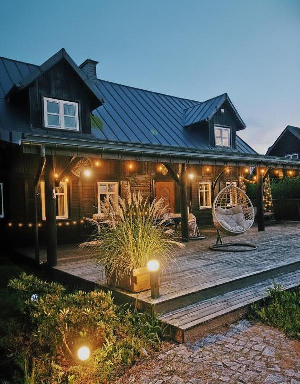 a house with a wooden deck in front of it at Mazurska Chata Rydzewo in Rydzewo