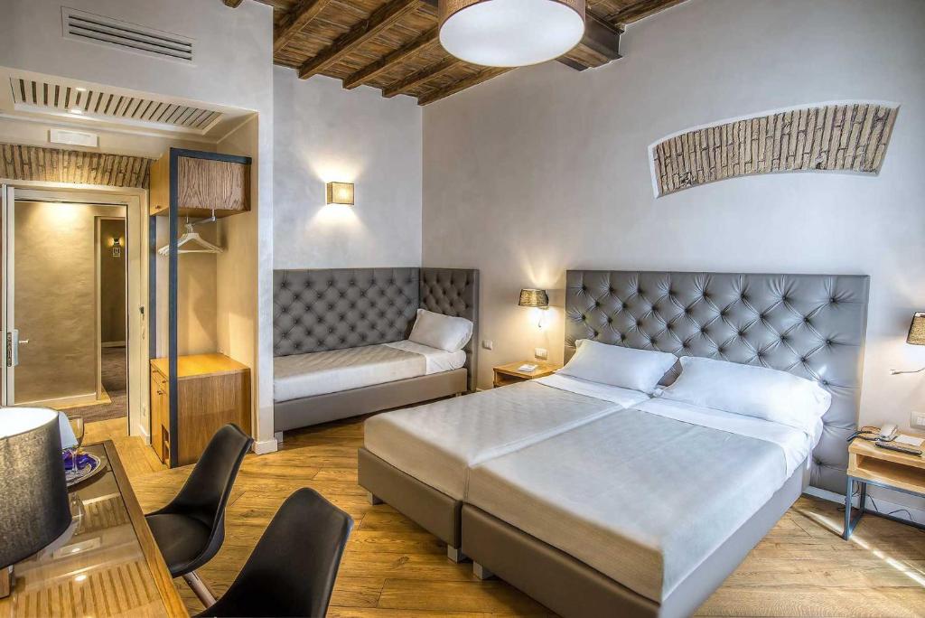 a bedroom with a bed and a desk and a couch at Hotel Elite in Rome