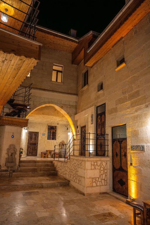 an old building with a staircase and an archway at Colina Stone House in Mustafakemalpaşa