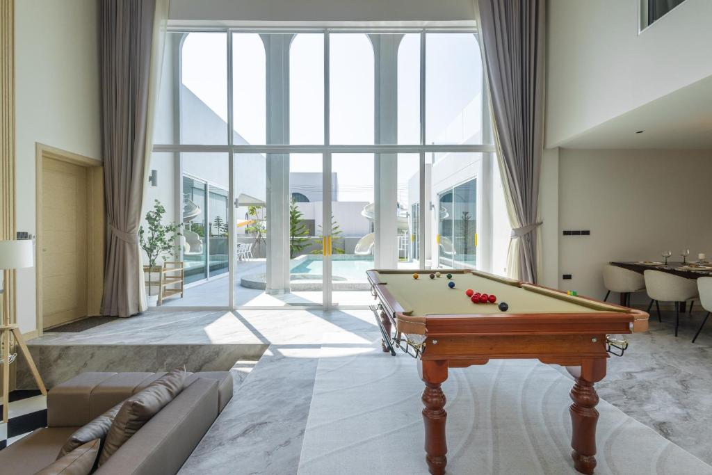 a pool table in a room with a large window at Luma & Malta PoolVilla Cha-am in Sathani Nong Ta Phot