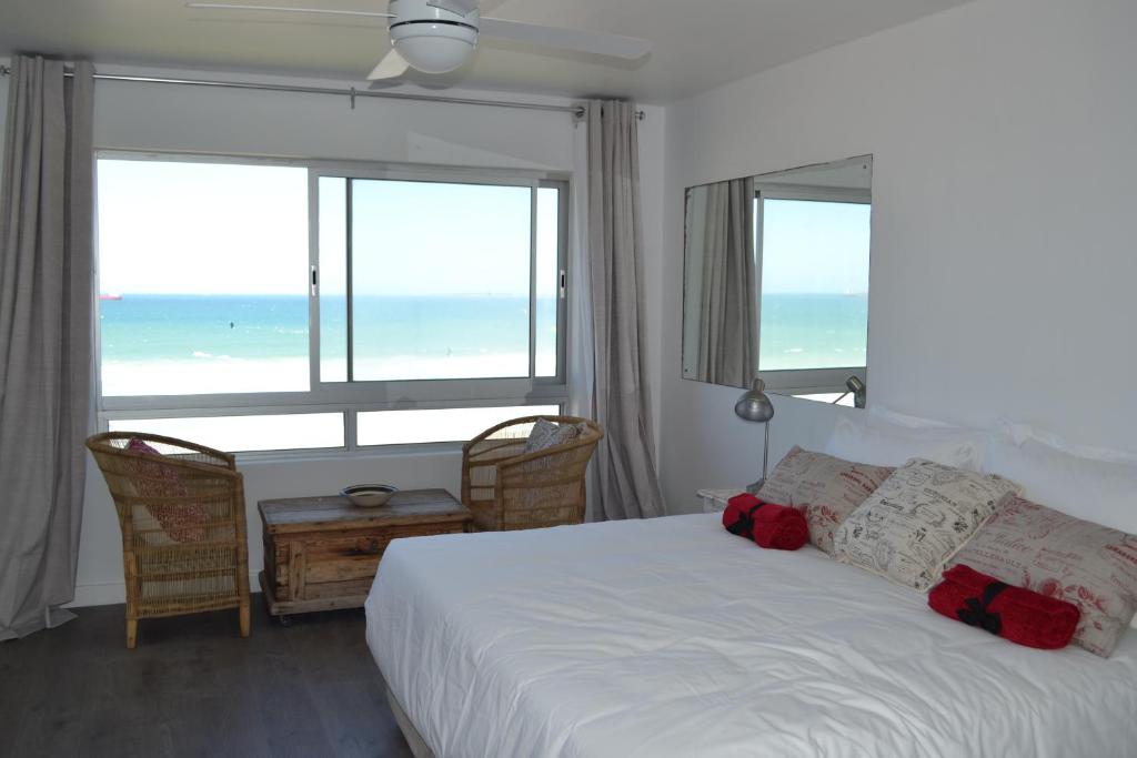 a bedroom with a bed with a view of the ocean at Blouberg Studio Wow in Bloubergstrand
