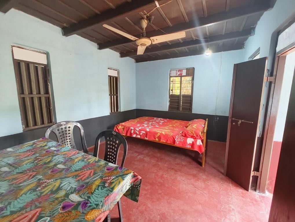 a room with a bed and a table and chairs at RR Homestay in Nīleswaram