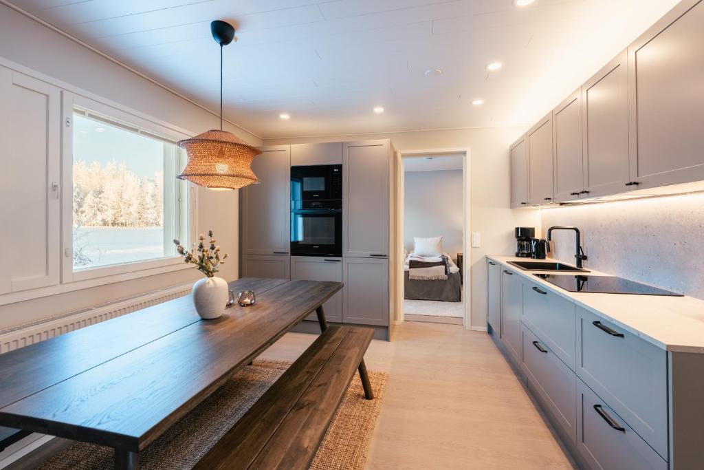 a kitchen with a wooden bench in front of a window at Lapland Lakeside Villa in Ranua