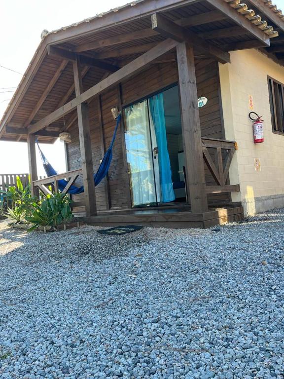 a house with a window with a blue curtain at Cabano rosa sul in Garopaba