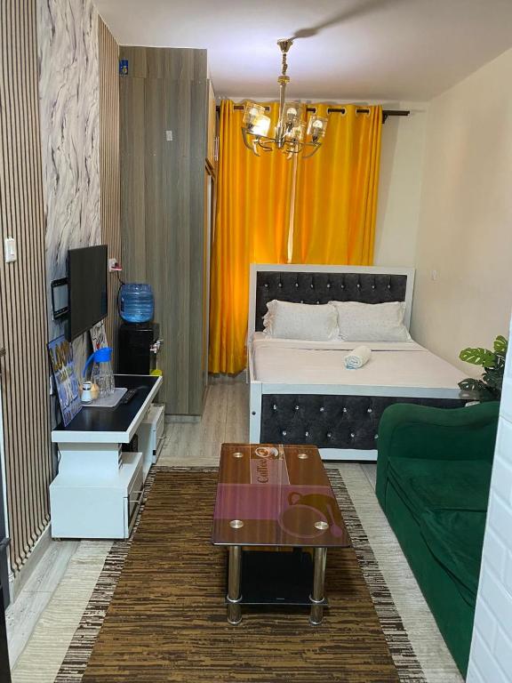 a living room with a bed and a green couch at RENE haven in Nairobi