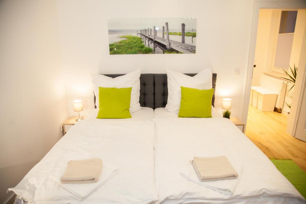 a bedroom with a large white bed with green pillows at Apartment Haus Heidelberg in Heidelberg