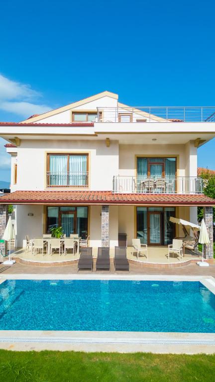 a villa with a swimming pool and a house at Gold villa in Fethiye