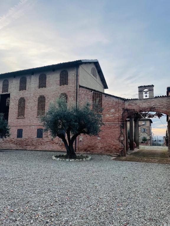 a brick building with a tree in front of it at BORGO VILLA VALENTINI in Scandiano