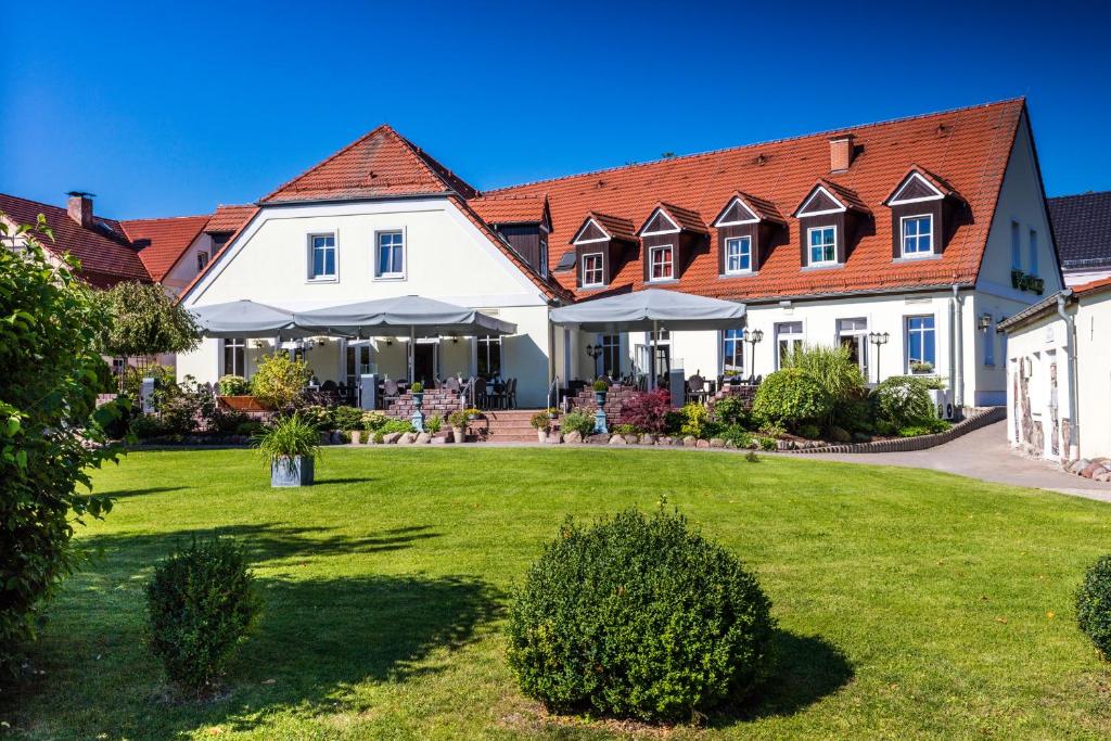 ein großes weißes Haus mit roten Dächern in der Unterkunft Hotel Prinz Albrecht in Neuzelle
