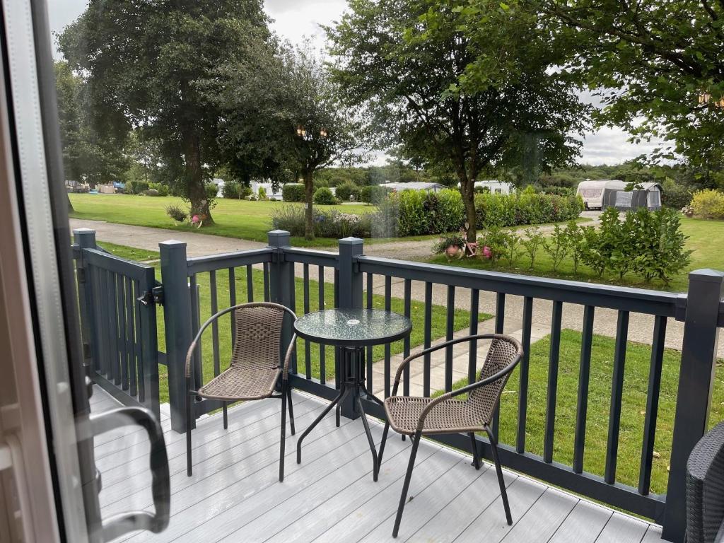 a table and chairs on a balcony with a view of a park at The Royal Oak - Sleeps 4 - Deck - Free Parking in Holsworthy