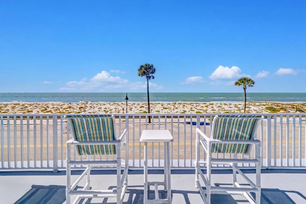 two chairs and a table on a balcony overlooking the beach at Pass-A-Grille Beach Retreat Unit 8 in St. Pete Beach