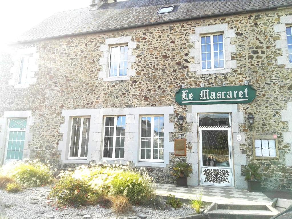 ein Steingebäude mit einem Schild, das vor dem Kamin steht in der Unterkunft Le Mascaret - Restaurant Hotel Spa - Teritoria in Blainville-sur-Mer