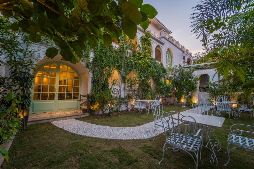 a garden with tables and chairs in front of a building at Lumira Queensbury Villa in Udaipur