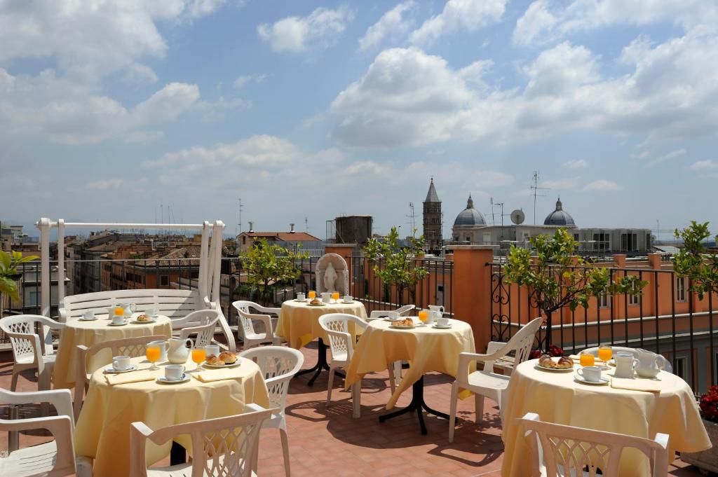 a patio with tables and chairs on a roof at Hotel Torino in Rome