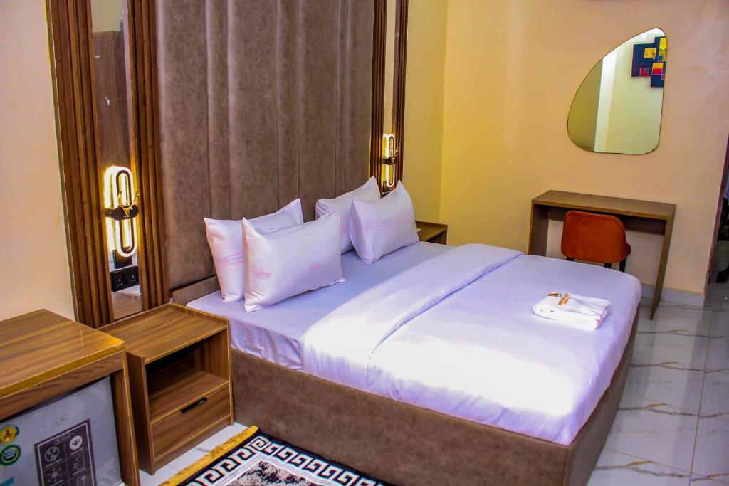 a bedroom with a bed with white sheets and pillows at Soulmate Hotels and Suites in Mawere