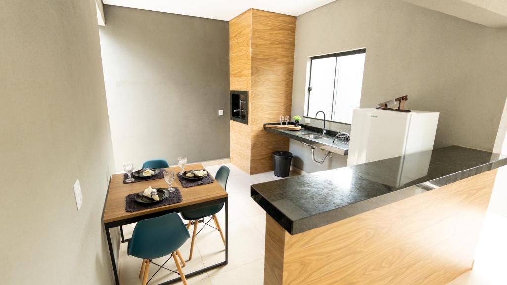 a kitchen with a table and chairs and a refrigerator at Jahu Center Casas Un 5 in Jaú