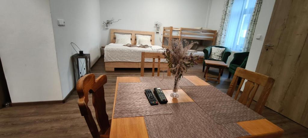 a room with a dining table and a bedroom with a bed at Hvězda in Želnava