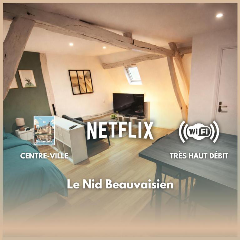 a room with a bed and a tv and a table at Le Nid Beauvaisien in Beauvais