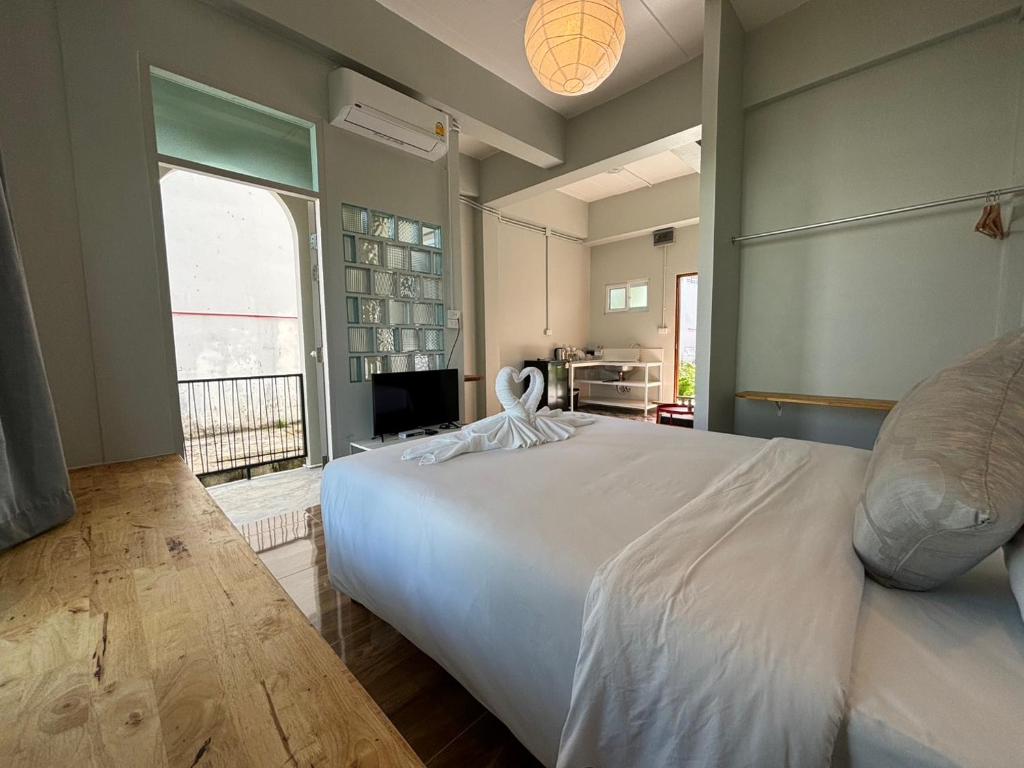 a bedroom with a large white bed and a window at T terrest Residence in Thai Muang