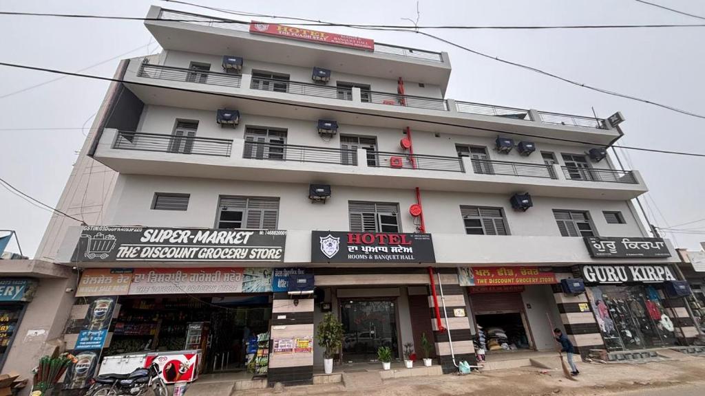 a large white building with shops in front of it at HOTEL The Puadh Stay in Lāndrān