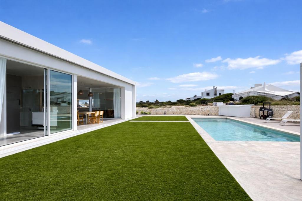 an image of a backyard with a swimming pool and grass at Villa Codolar in Cala Morell