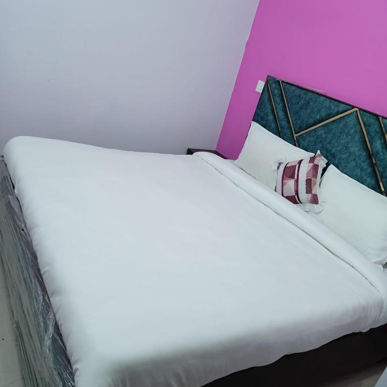 a bed with white sheets and pillows in a room at AG Hotel in Zirakpur