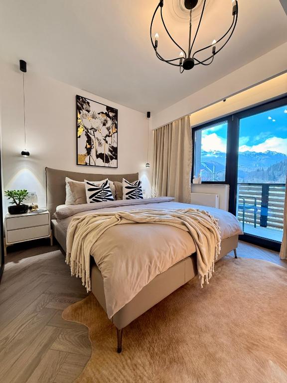 a bedroom with a large bed and a large window at Greg Rooms in Sinaia