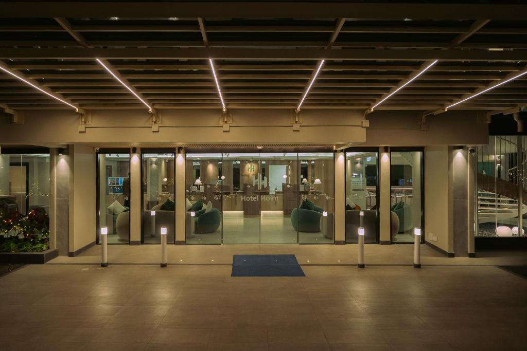 a room with glass doors and a room with furniture at Hotel Holm Bangkok in Bangkok