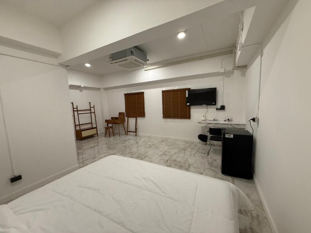 a white room with a bed and a desk at S77 Good View in Roi Et