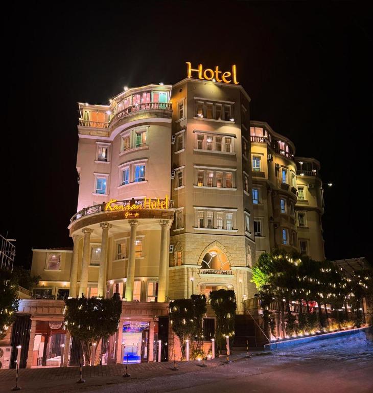 a hotel building with a sign on it at night at Kanaan Group Hotel in Baalbeck