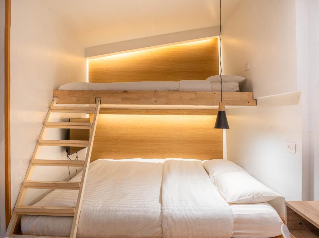 a room with two bunk beds and a ladder at The Goose House Ubon in Ban Na Khwai