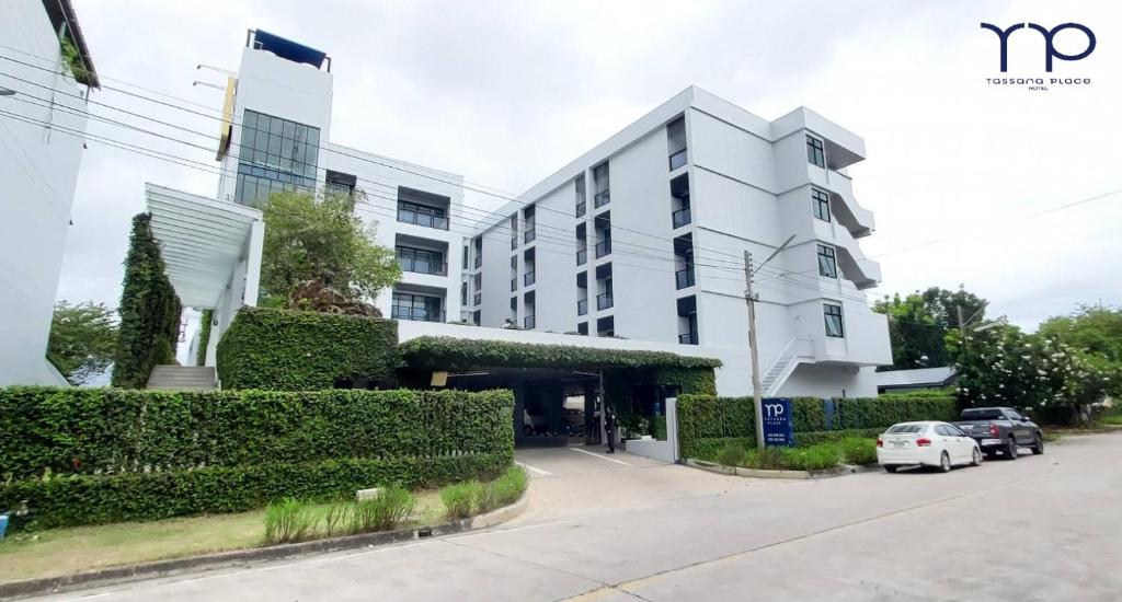 a white building with cars parked in front of it at Tassana Place in Chon Buri